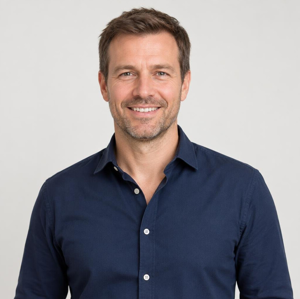 Portrait of a smiling man with short brown hair in a casual shirt
